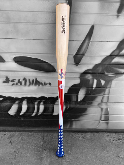 American flag HC Bats RM13 Pro Select Maple baseball bat with stars and stripes handle and natural barrel displayed horizontally on a white background.
