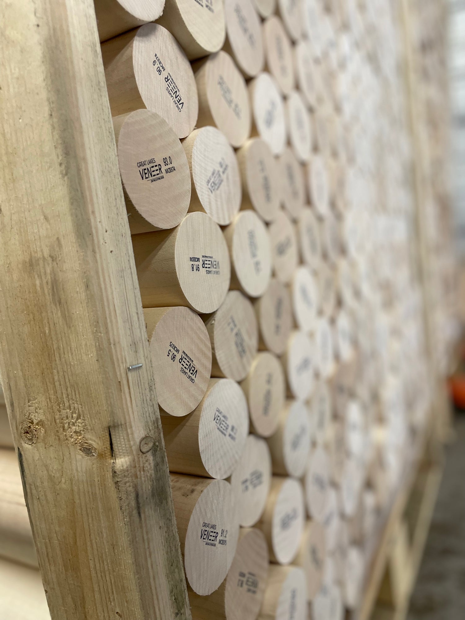 Stack of wooden logs with labels on a wooden pallet