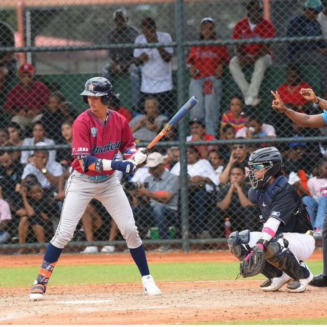 Baseball player at bat with catcher behind home plate, spectators in the background